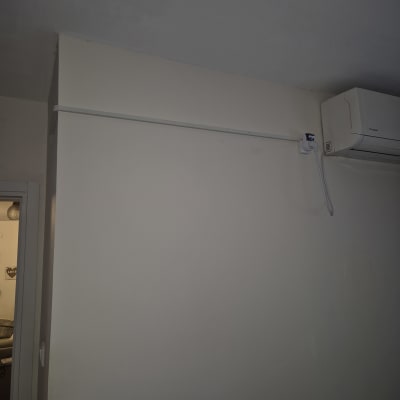 מזגן מותקן על קיר עם חוטי חשמל