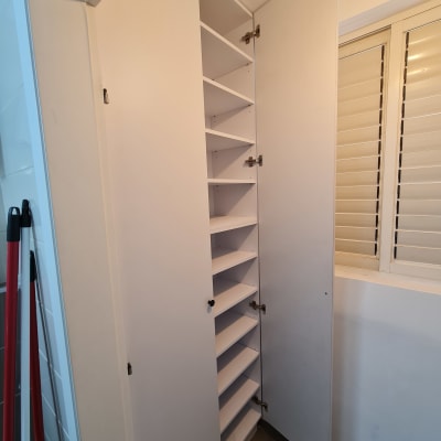 ארון פתוח עם מדפים ודלתות בחדר קטן