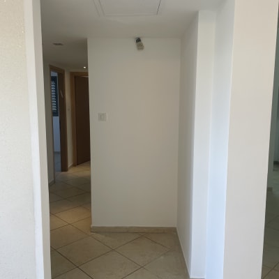 קיר צבוע בלבן עם רצפת אריחים