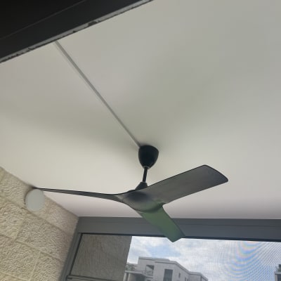 מאוורר תקרה שחור מותקן על תקרה לבנה