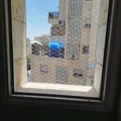 רשת יונים מותקנת על חלון למניעת כניסת יונים