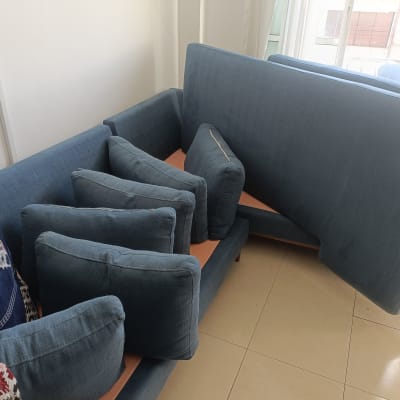 ספות וכריות כחולות מונחות בחדר מואר