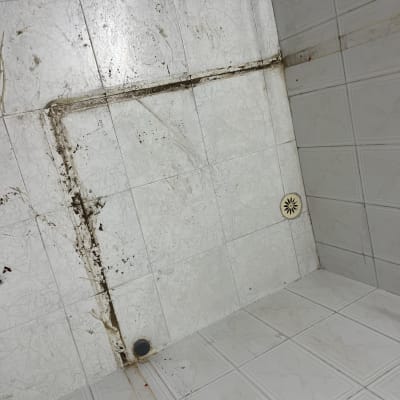 רצפת אריחים מלוכלכת עם כתמים וניקוז