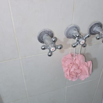 ברזי מים על קיר אריחים בחדר אמבטיה