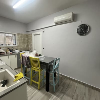 מטבח עם שולחן וכיסאות צבעוניים, קיר צבוע ולבן