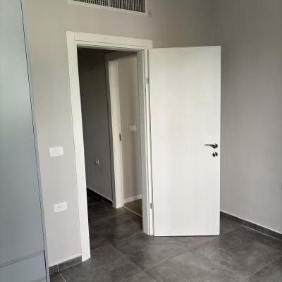 חדר צבוע עם דלת פתוחה ורצפת אריחים אפורים