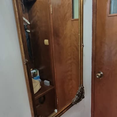 מראה עם מסגרת מעוטרת תלויה על קיר