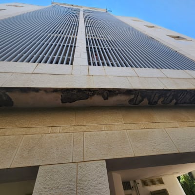 בניין עם קיר מתקלף ונזק לצבע