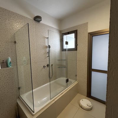 אמבטיה עם דלת זכוכית ומקלחת ידנית