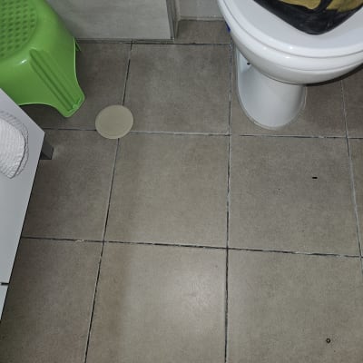 רצפת אריחים עם פתח ניקוז בחדר אמבטיה