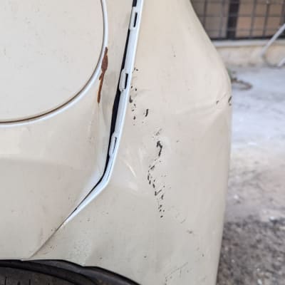 נזק לפגוש אחורי של רכב עם שריטות וחלודה