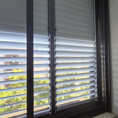 חלון אלומיניום עם תריסים אופקיים פתוחים למחצה