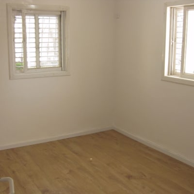רצפת פרקט עץ בחדר ריק עם חלונות