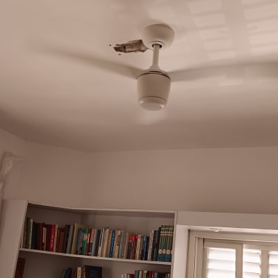 מנורה תלויה מהתקרה עם חור בקיר ליד