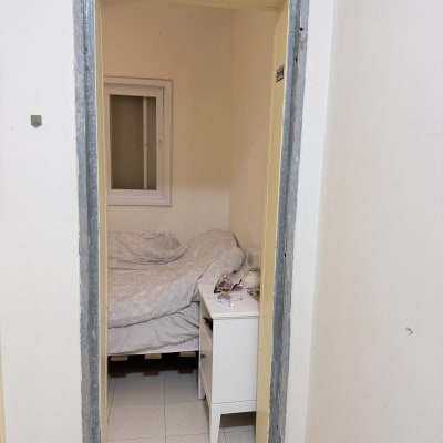 מסגרת דלת ללא דלת, חדר עם מיטה ושידה