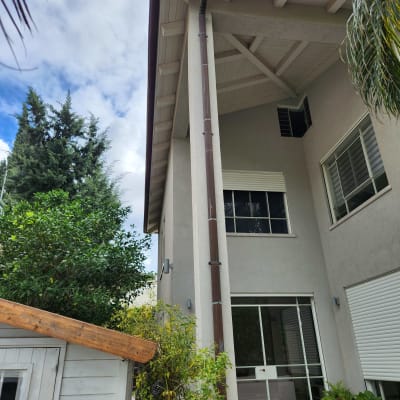 גג רעפים עם מרזב חום על בית דו קומתי