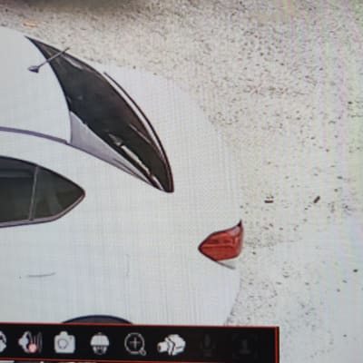 חלק אחורי של רכב לבן עם חלון פתוח