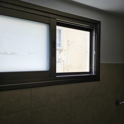 חלון אלומיניום עם זכוכית חלבית וקיר חיצוני