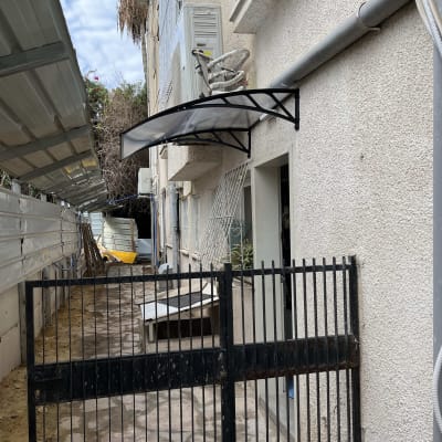 סוכך שחור מותקן מעל דלת כניסה לבניין.