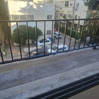 מעקה מתכת שחור על מרפסת עם רצפת עץ