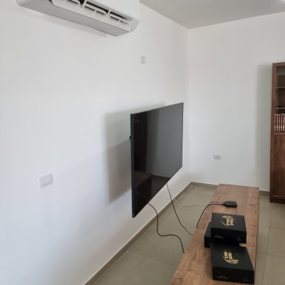 קיר צבוע עם מזגן וטלוויזיה תלויה