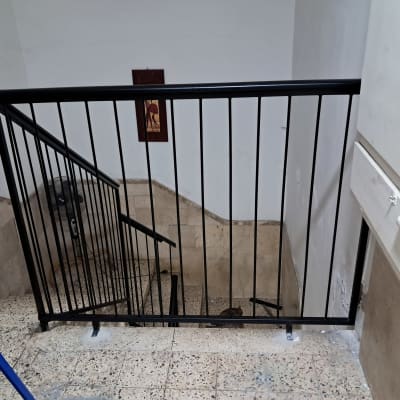 מעקה מתכת שחור במדרגות בניין