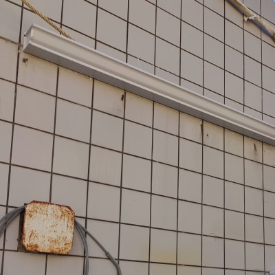 מרזב מתכת על קיר מרוצף באריחים