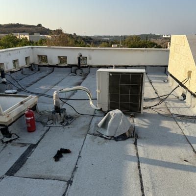 גג עם יריעות איטום, מזגן וכפפה שחורה