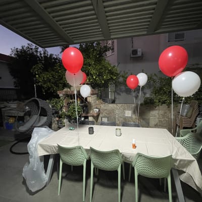 בלונים אדומים ולבנים על שולחן עם מפה לבנה