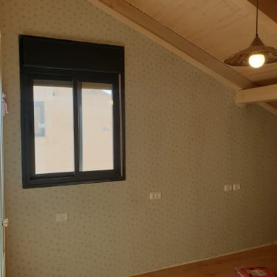 קיר עם טפט פרחוני קטן וחלון שחור