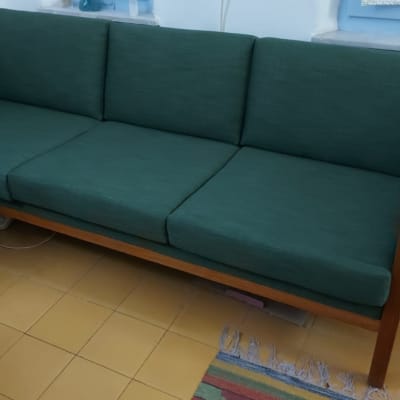 ספה ירוקה עם ריפוד מרובע על רצפה צהובה