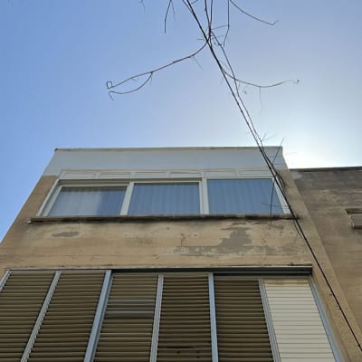 חזית בניין עם חלונות ותריסים פתוחים