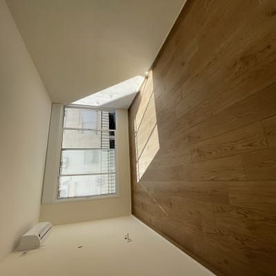 חדר ריק עם רצפת עץ נקייה ואור טבעי