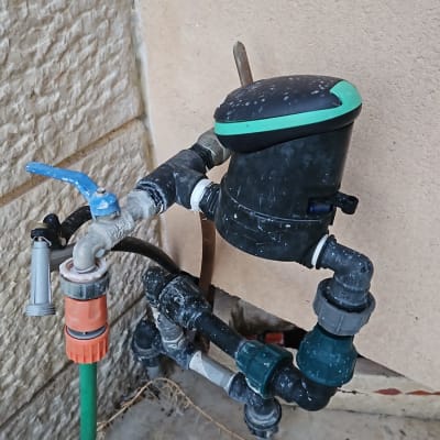 ברז מים עם צינור ירוק ומחבר פלסטיק