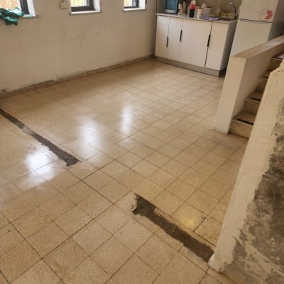 רצפה רטובה עם סימני ניקוי, מטבח ברקע