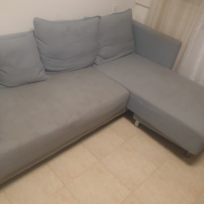 ספה אפורה עם כריות על רצפת אריחים