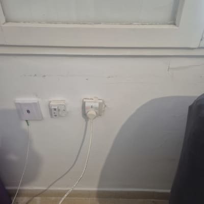 שקעי חשמל וכבלים על קיר לבן