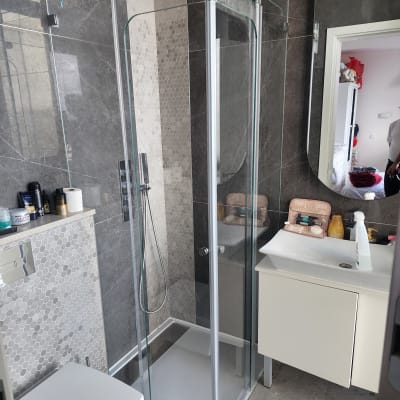 מקלחון זכוכית עם דלתות שקופות ומקלחת יד