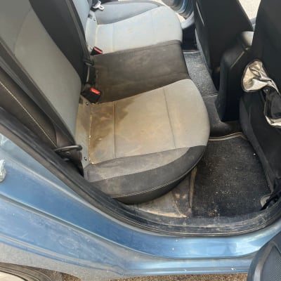 מושב רכב מלוכלך עם כתמים ולכלוך על הרצפה