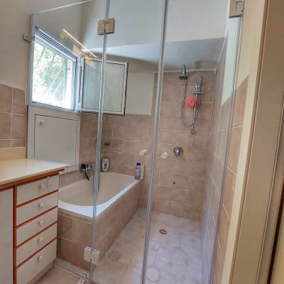 מקלחת עם דלת זכוכית, ראש מקלחת וסבון