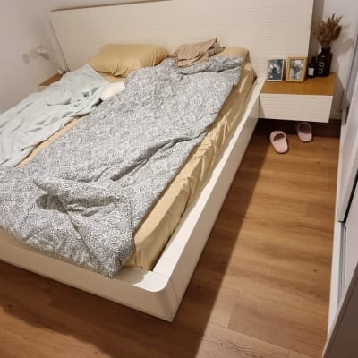 רצפת פרקט בחדר שינה עם מיטה מסודרת