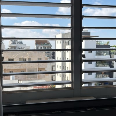 נוף עירוני מבעד לתריסים פתוחים