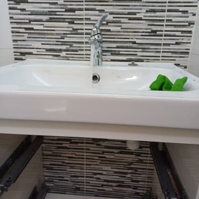 כיור עם ברז, סמרטוט ירוק, צינור מתחת לכיור