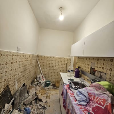 חדר עם קירות צבועים בלבן, מנורה תלויה מהתקרה