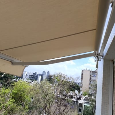 סוכך זרועות מותקן על בניין עם נוף עירוני