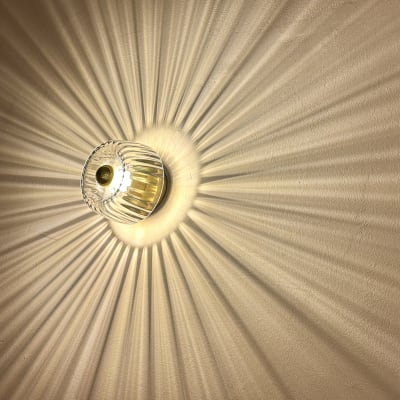 מנורה עגולה עם קרני אור על הקיר