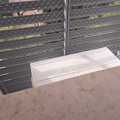 רשת מתכת מותקנת על מרפסת למניעת כניסת יונים