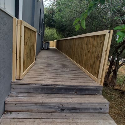 שביל עץ עם מעקה עץ לצד מבנה