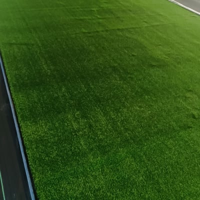 התקנת דשא סינתטי בחצר על ידי אדם