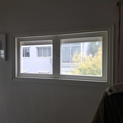 חלון זכוכית עם נוף חיצוני של בניין ועצים